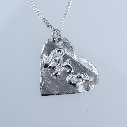 One-of-a-kind silver heart necklace with textured patina and bold lettering