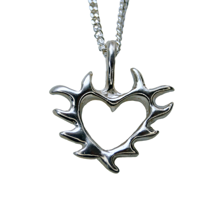 A silver pendant with a tattoo-inspired open heart design attached to a silver chain.