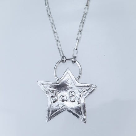 Textured sterling silver star pendant with puffed "BABY" letters, white background