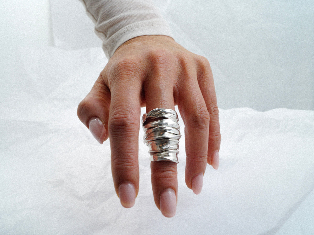 Hand wearing the statement-size Fold 004 sculptural sterling silver ring