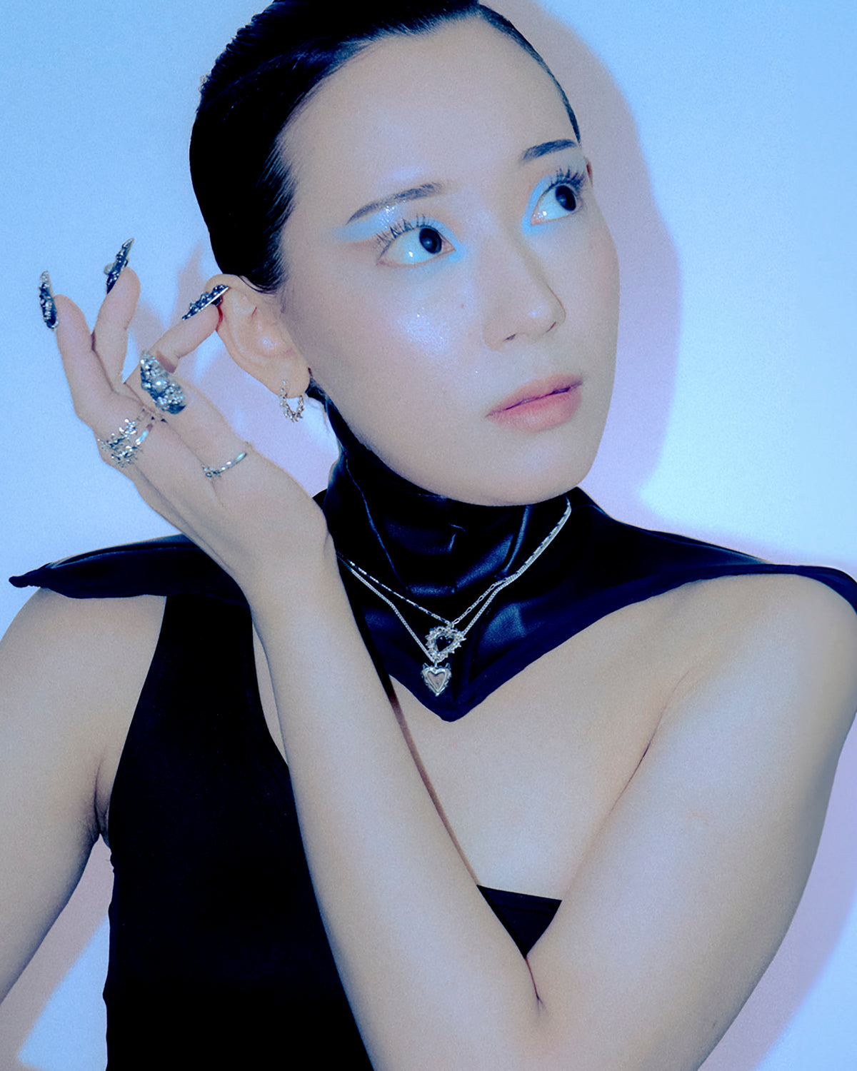 Model wearing the Baddie silver heart pendant with layered necklaces