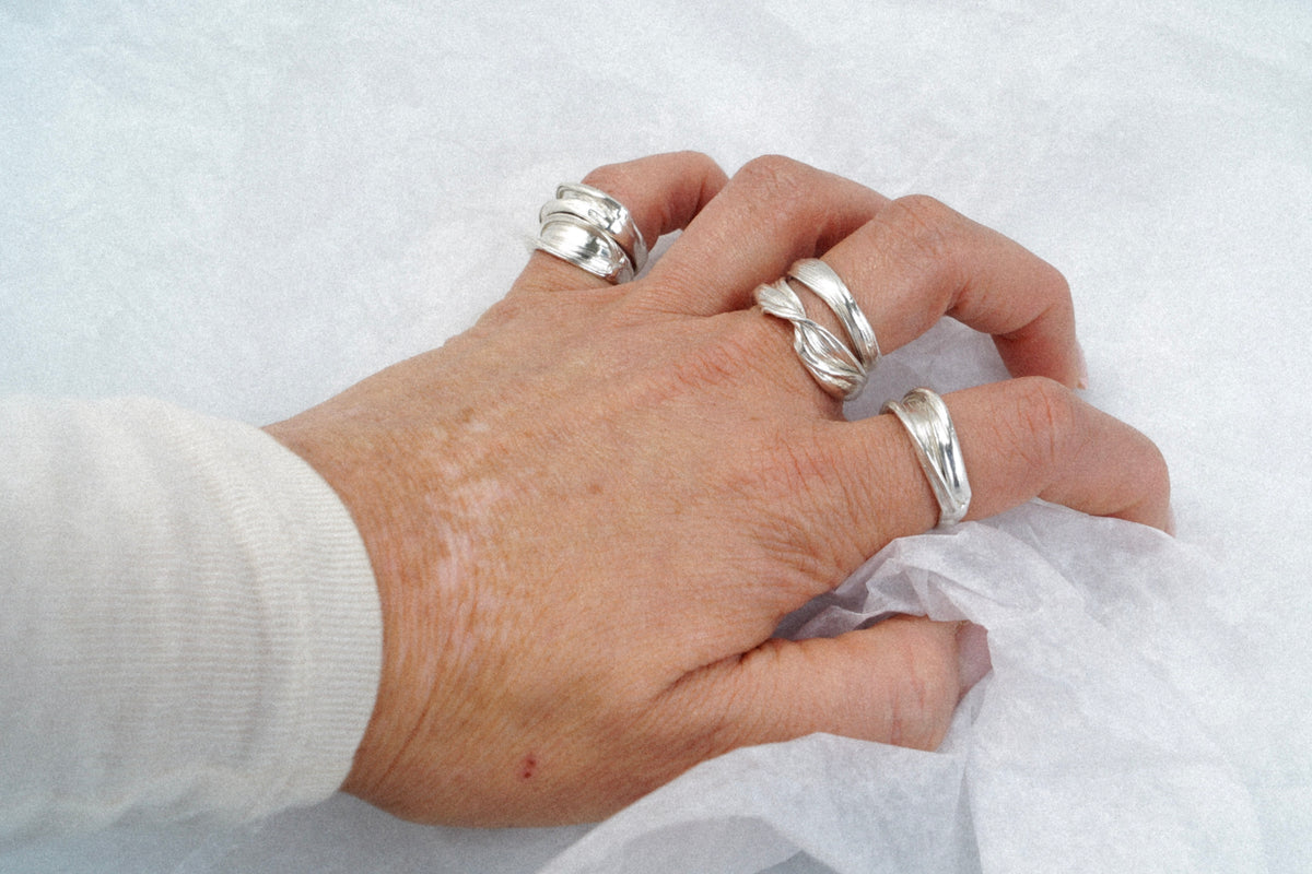 Hand styled with a collection of sculptural sterling silver Fold rings