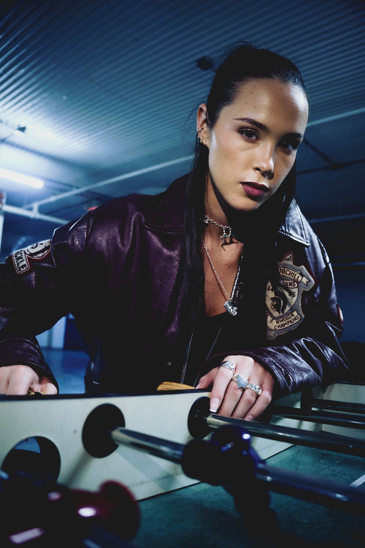 Model wearing the Big Baby sterling silver pendant necklace while playing foosball