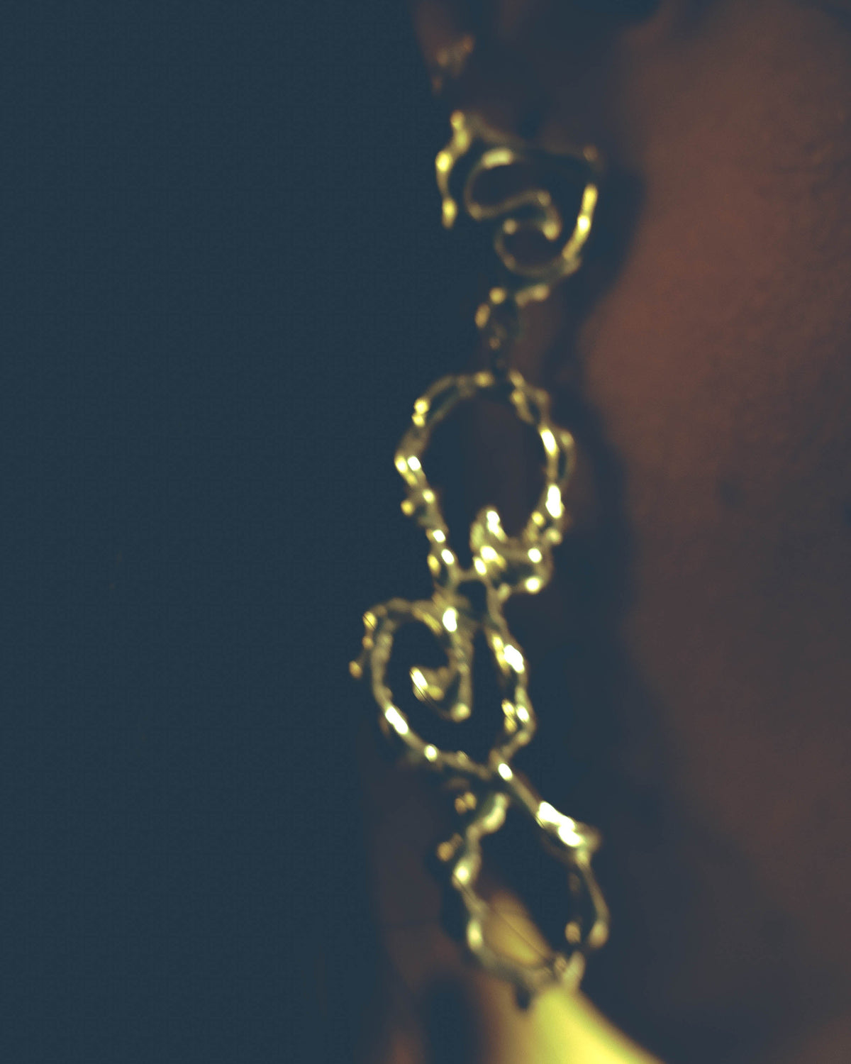 Close-up of Fluid Wave sterling silver earrings worn on the ear