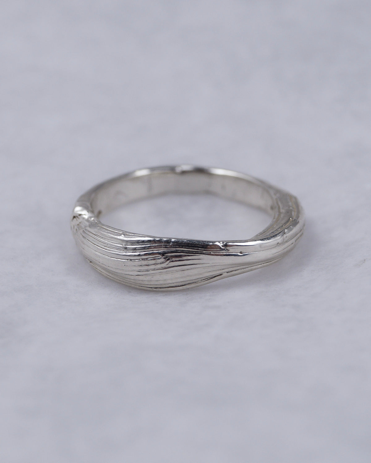 Fold 003 sterling silver ring photographed on a pale surface