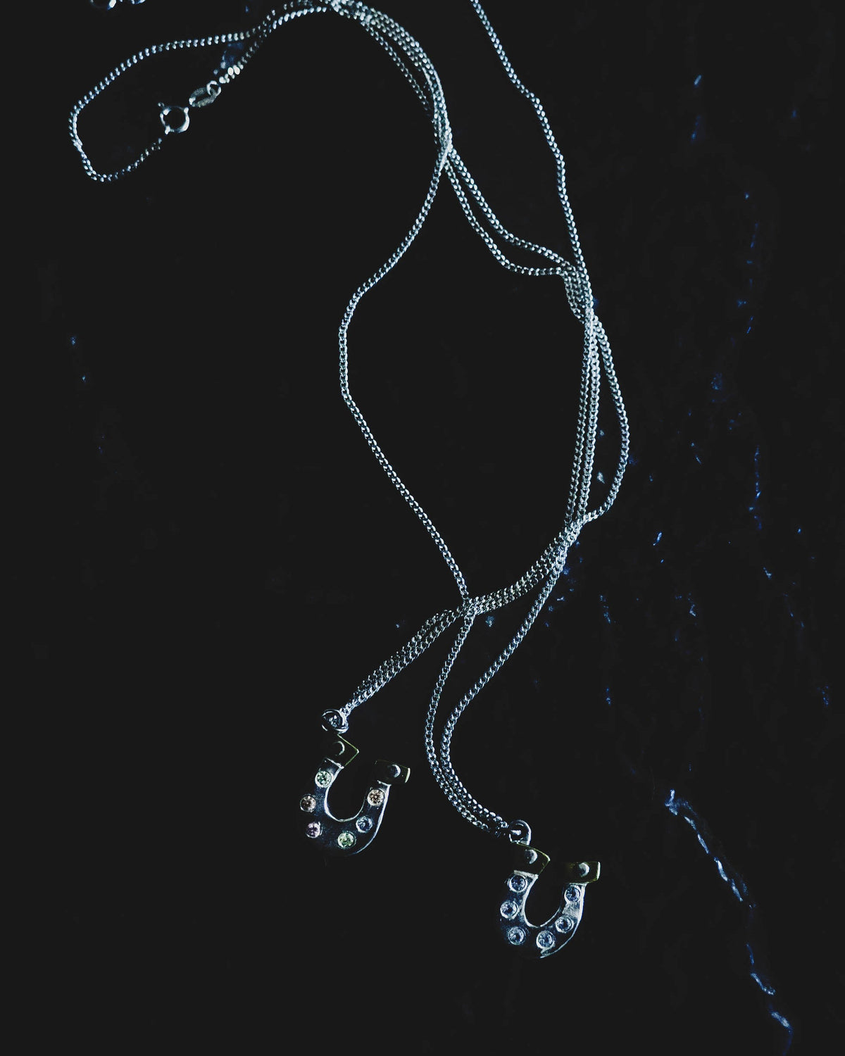 Lucky You sterling silver and brass pendant necklace on a dark background