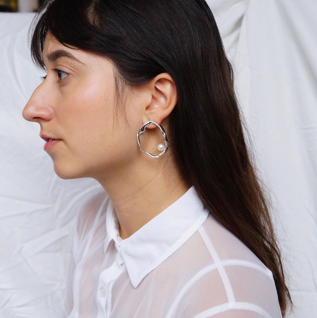 Model wearing Mother sterling silver hoop earrings with freshwater pearls